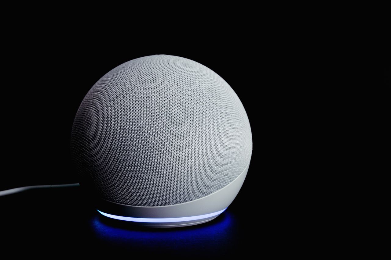 services-01 Modern smart speaker device with illuminated ring, featured on a dark background.